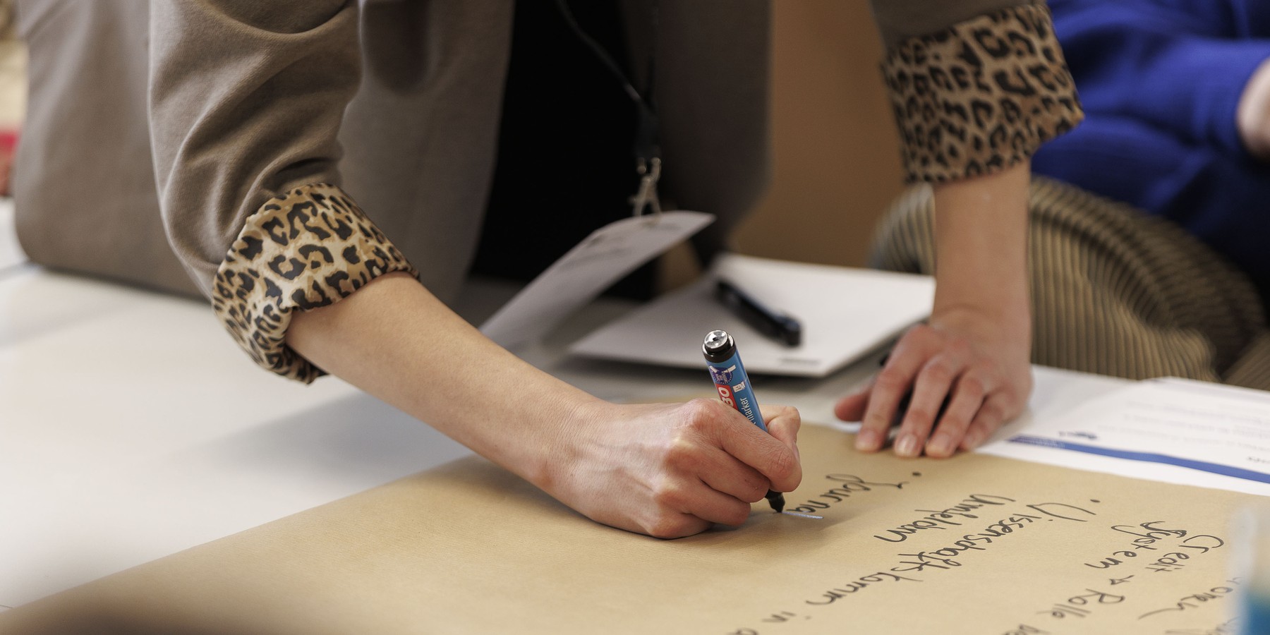 Frau schreibt etwas auf ein Plakat